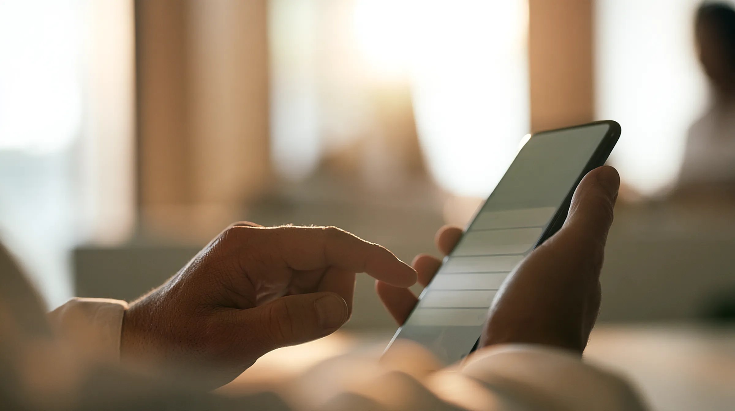 An owner's hands holding the clinic phone, a long stack of unread messages on screen